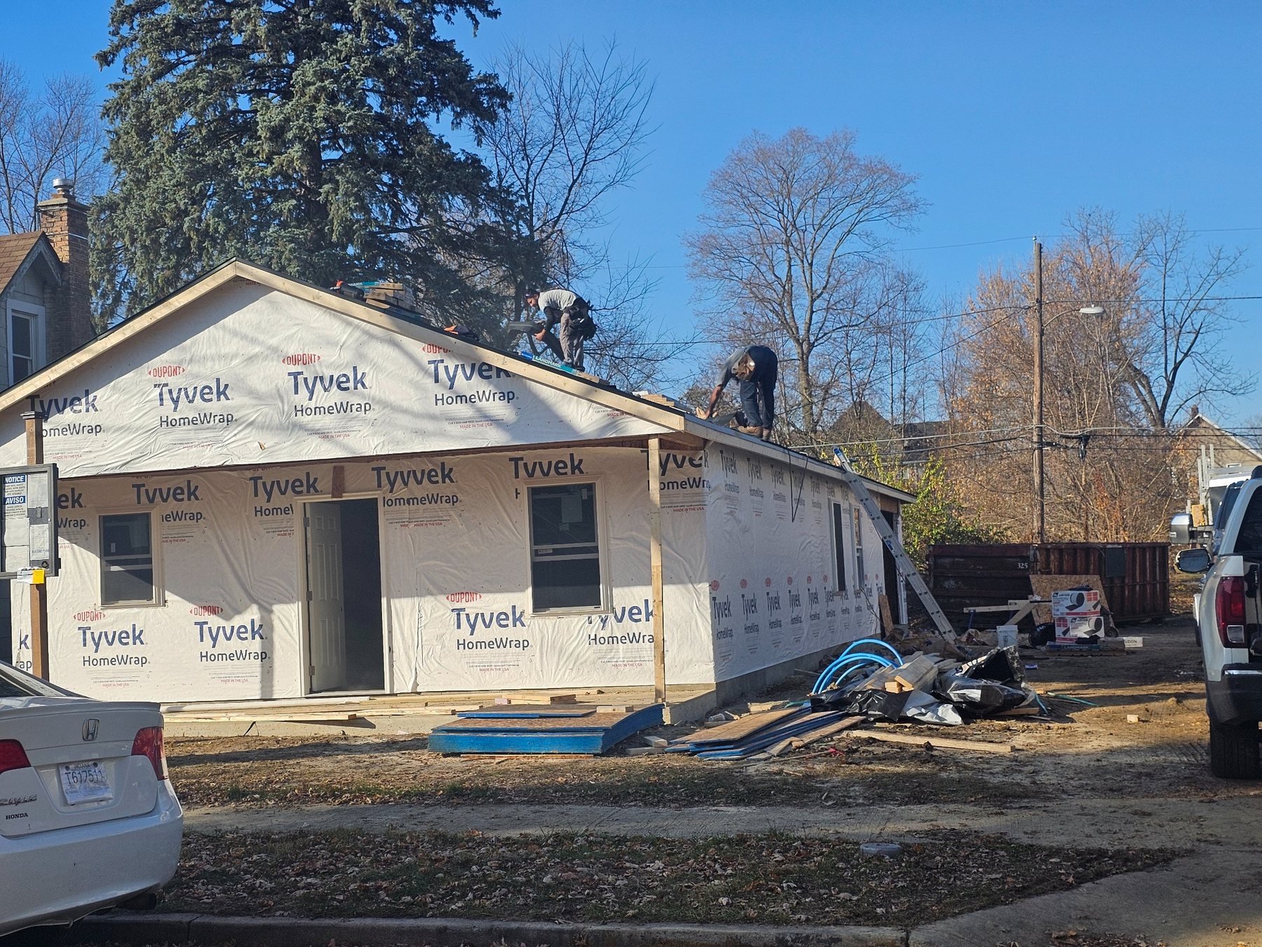 House under construction with roofers working